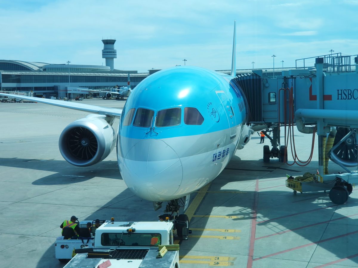 Airplane parked at an airport gate with a jet bridge attached