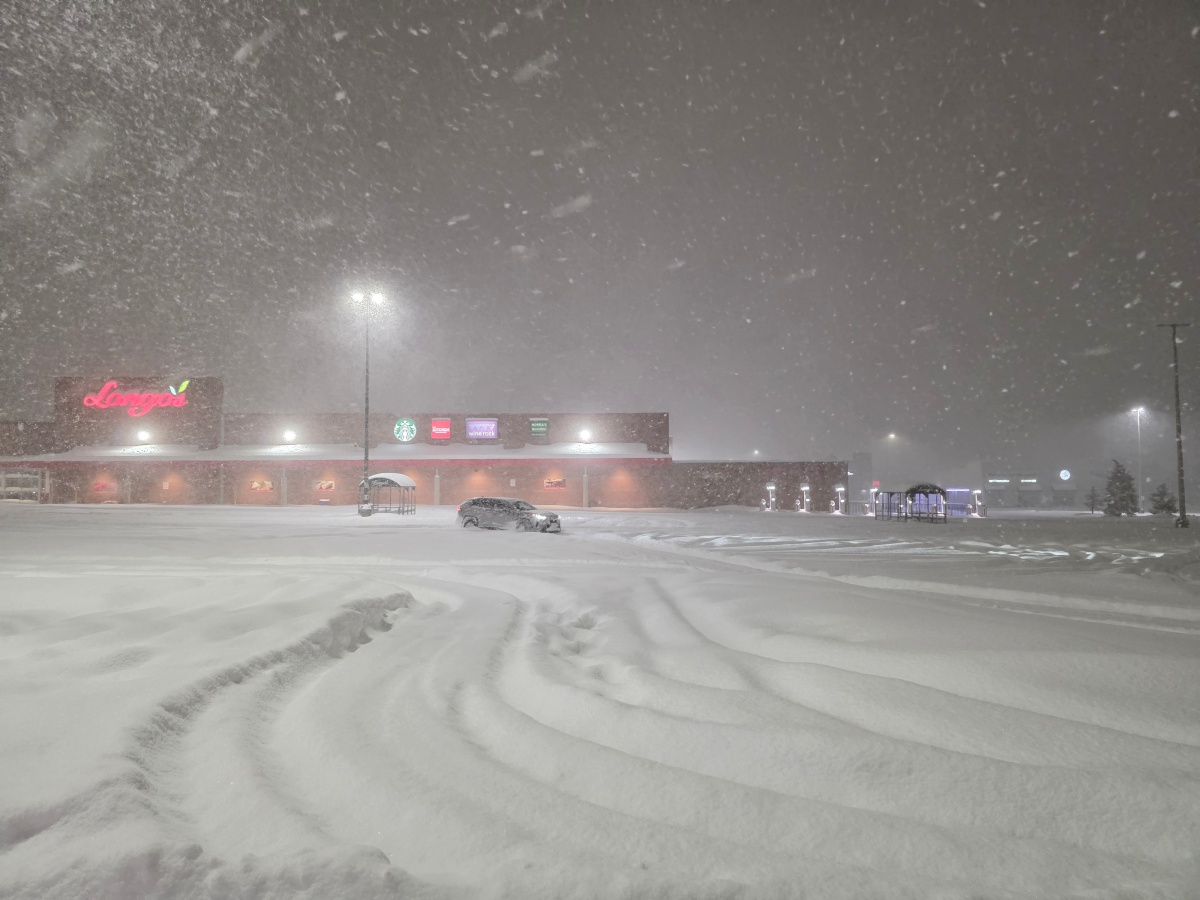 Snow-covered parking lot with tire tracks after heavy snowfall