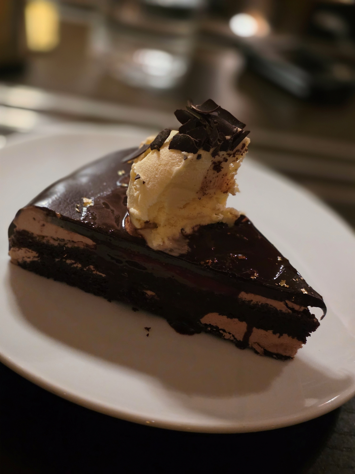 A single slice of rich chocolate layered cake served on a white plate