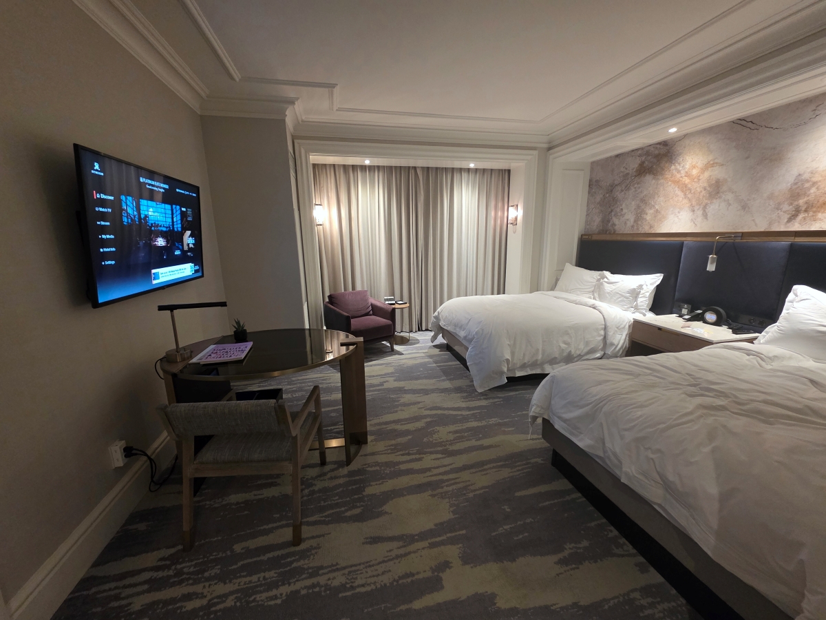 Hotel guest room featuring two large beds with crisp white linens