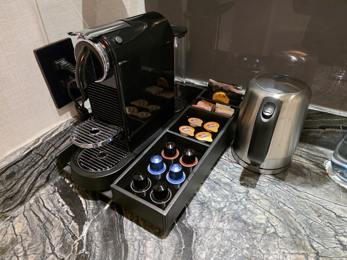 Nespresso coffee machine and an assortment of coffee pods on a marble counter