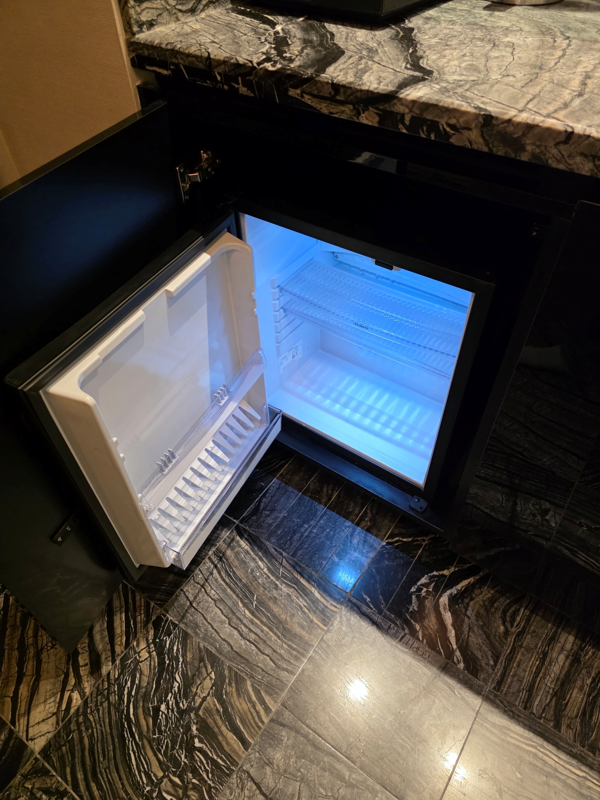 View inside the illuminated mini-fridge in the guest room