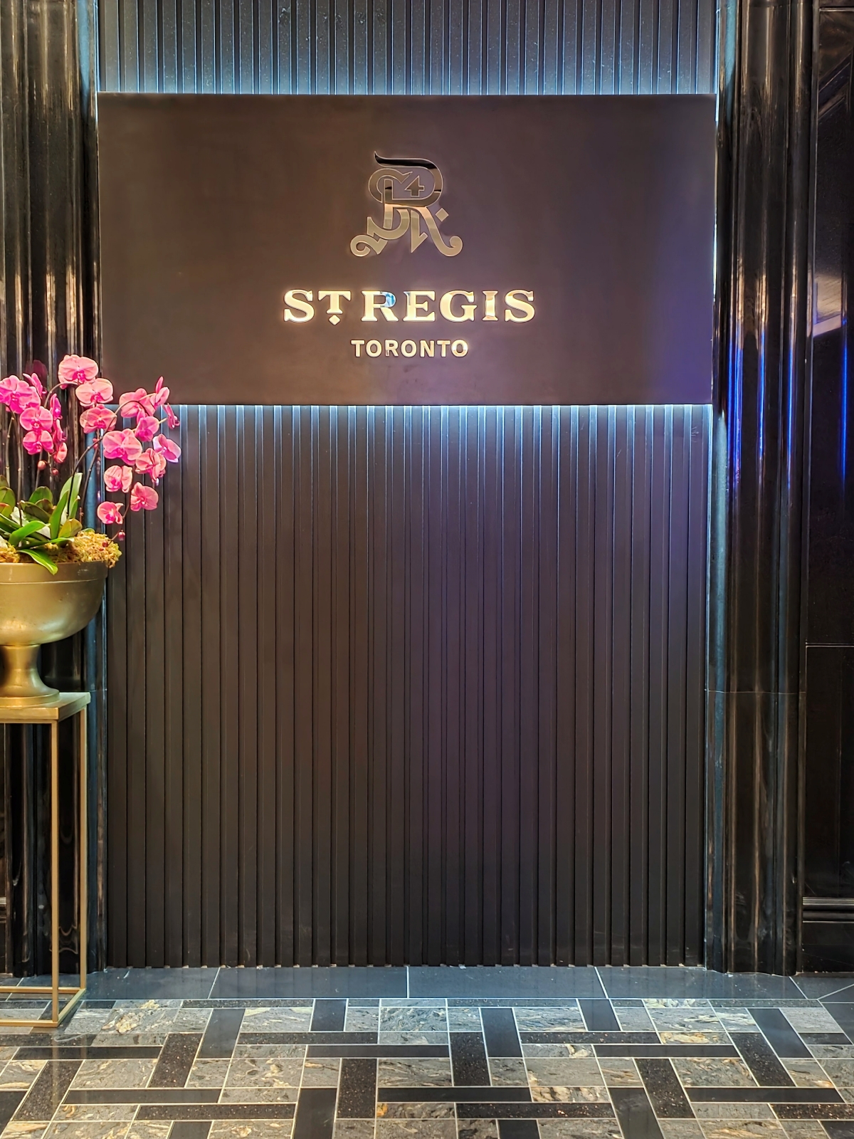 The St. Regis Toronto logo and sign on a dark textured wall