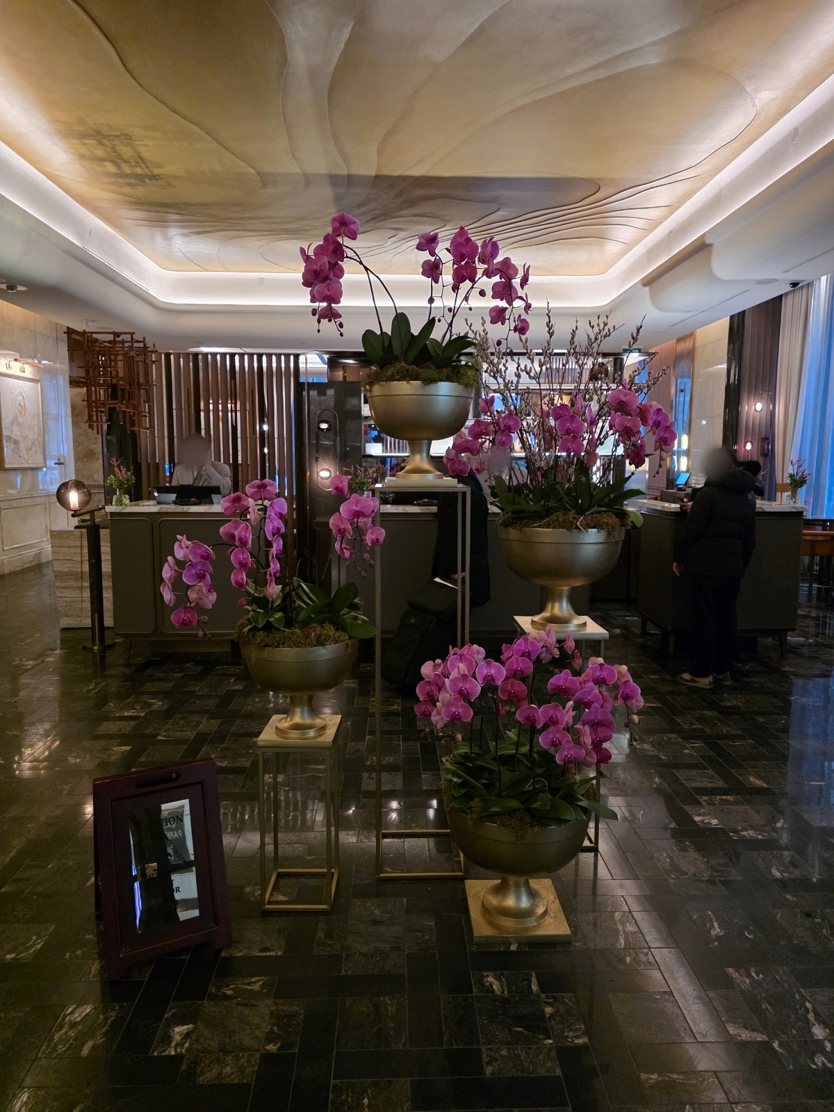 The luxury hotel lobby featuring large, vibrant purple floral arrangements