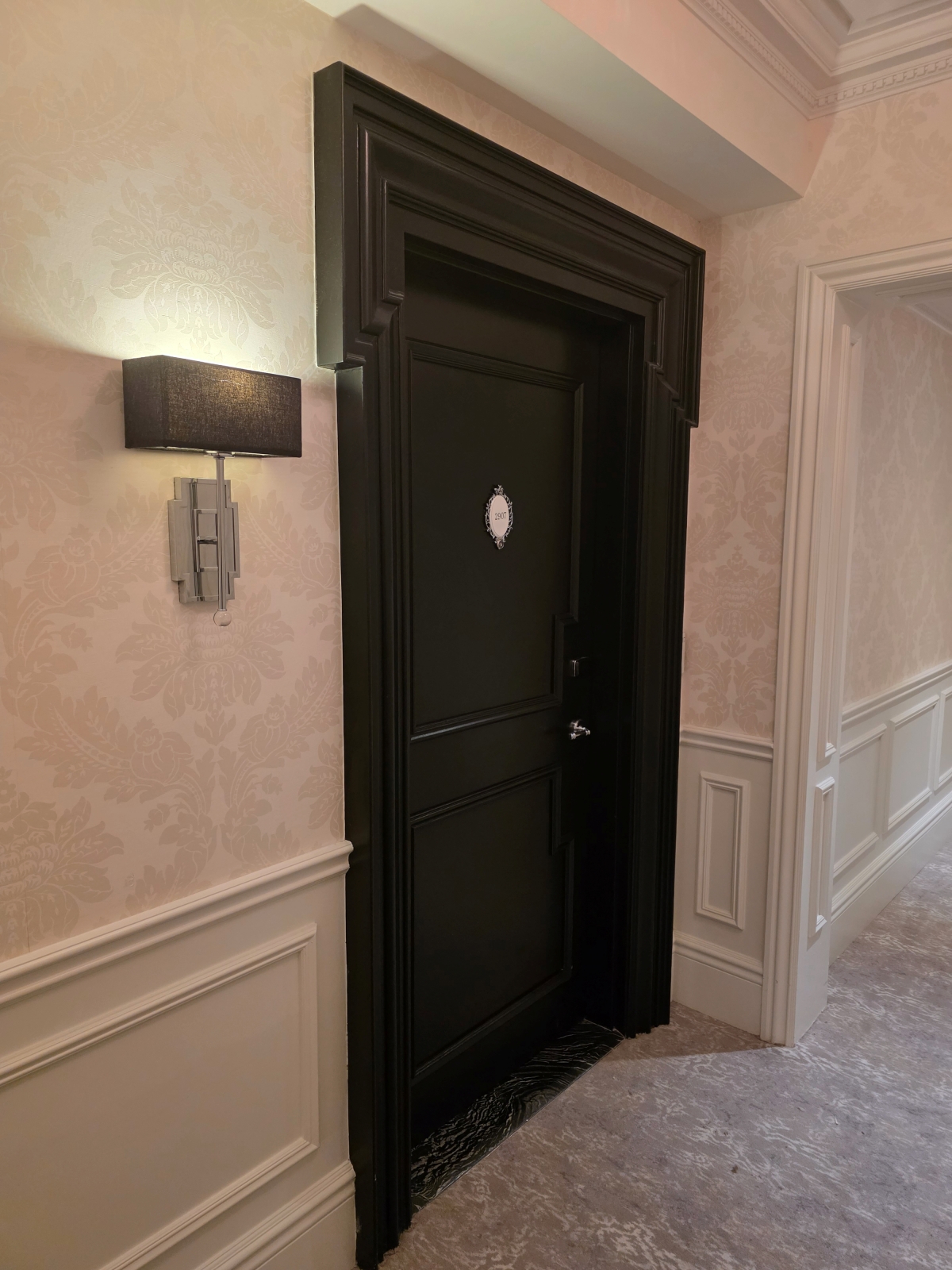 The heavy, dark wood hotel room entry door