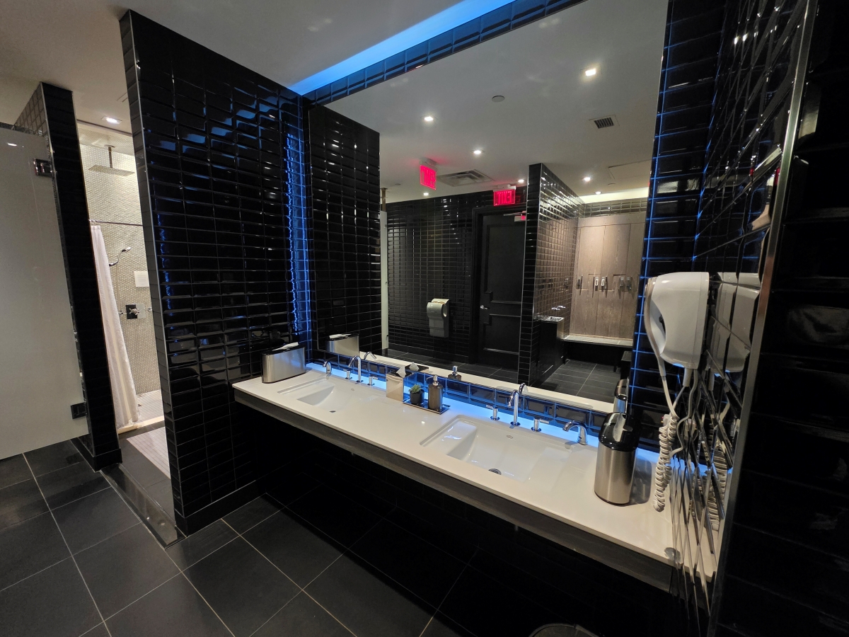 Modern black and white spa vanity with multiple sinks and large mirrors