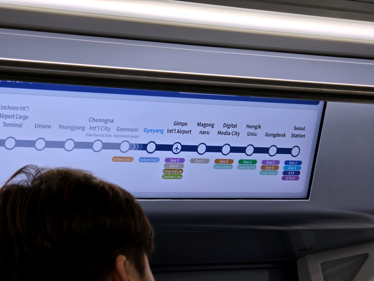 Digital display inside the AREX train highlighting transfer stations to other Seoul subway lines