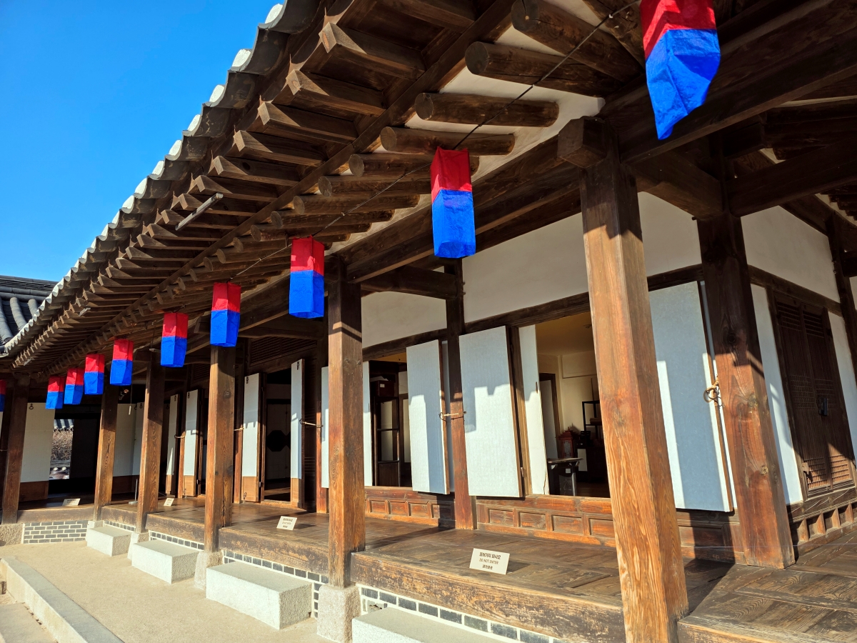 Red and blue lanterns hanging on a Hanok exterior