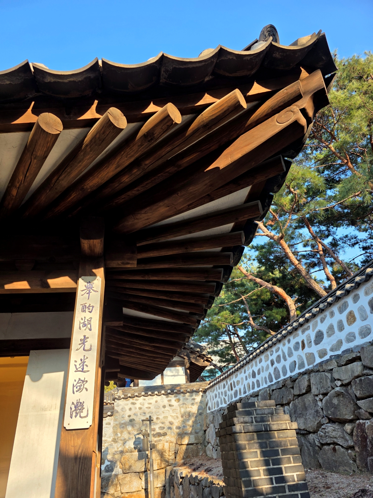 Corner view of a Hanok roof and stone wall
