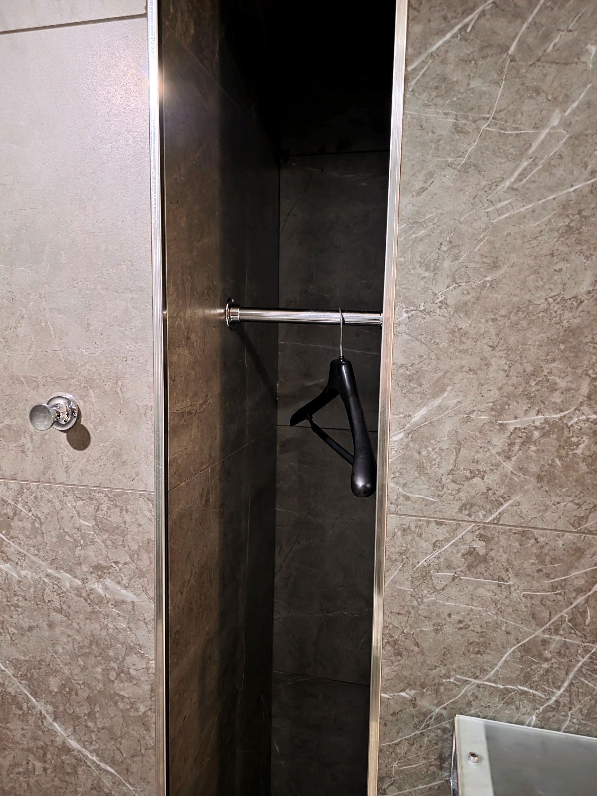 Closet space with hangers inside the Maple Leaf Lounge shower room