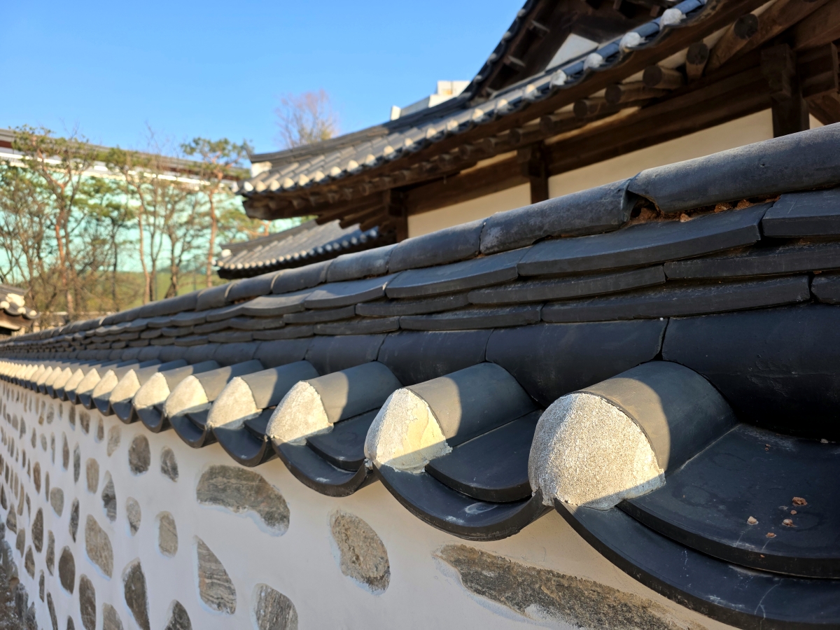 Traditional Korean stone and mud wall with tiled roof
